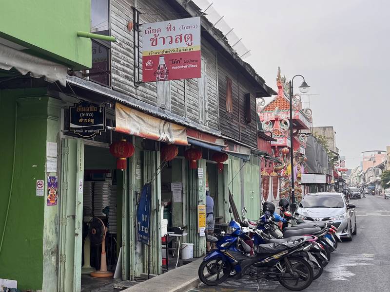 ป้ายร้านเกียดฟั่งเหนือห้องแถวไม้เก่าบนถนนนางงาม